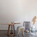 Round dining table styled in a minimalist room with neutral decor and soft natural light