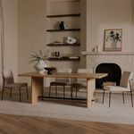 Four Danny Dining Chairs styled around wood dining table in warm living space with fireplace