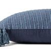 Side view showing pillow thickness with tassels and solid dark blue fabric back