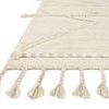 Close-up side angle showing thick braided fringe and textured edge details of the rug