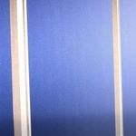 Close detail of vertical white beams on blue gradient background showing fine texture and color shading