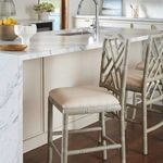 Side view of single stool in kitchen setting showing seat height relative to marble countertop and surrounding stools