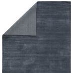 dark blue rug folded to reveal back side with finer vertical stripe pattern and lighter shade