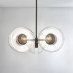 Chandelier in a room setting with bulbs lit inside clear glass globes, highlighting illumination