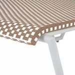 Close-up of natural and white woven wicker detail with white metal frame on chaise corner