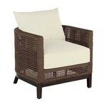 Outdoor barrel chair with dark brown woven raffia frame and cream seat and back cushions on wooden legs