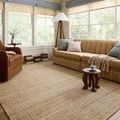Judy Natural Cream Rug styled in a bright living room with tan sofa, leather chair, and floor lamp