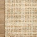 Close-up of rug corner on wooden floor highlighting dense plush texture and pattern detail