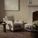 Lynne Chair styled in a living room setting with patterned rug, neutral walls, fireplace, and side tables