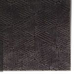 Top view close-up of detailed black geometric triangle pattern with plush, varying pile heights