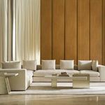 Bello Corner Wedge sofa in a room setting with modern coffee table, neutral rug, wood panel wall, and tall curtains