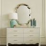 Aksel Lamp on white dresser under decorative mirror in softly lit room setting