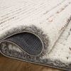 Curled edge of Levitt Ivory shag rug revealing rug backing and high pile softness