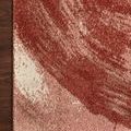 Detailed side view of rug edge showing compact binding and fiber texture against dark wood floor.