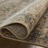 Close-up of rug edge folded to reveal tight weave and pile texture on wood floor