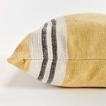 Close-up side seam with zipper detail on yellow striped woven fabric pillow