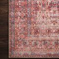 Detailed close-up of Loren Rug border with floral motifs on a dark wood floor for scale and contrast
