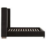 Side profile of bed frame without mattress focusing on velvet upholstery and oak feet