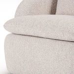 Close-up of seat cushion edge with textured bouclé upholstery and supportive base below