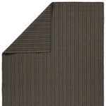 Back side of rug flipped corner showing reverse striped pattern in gray and charcoal hues