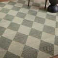 Close-up of Francis Spa granite rug texture showing wool fibers and diamond pattern near chair and side table