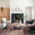 Jules Merlot Multi Rug styled in living room with black fireplace, wooden coffee table, and metal-frame chairs