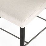 Close-up of seat upholstery seam and black wood front leg with iron-dipped cap