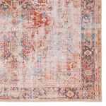 Close-up of rug edge showcasing intricate tribal floral border in rust and navy colors