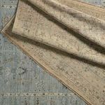 Layered fold showing contrast between beige woven backing and blue-green floral front design with close weave texture