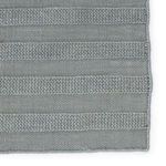 Close-up showing woven texture and striped pattern in corner of rug
