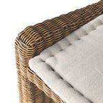 Front armrest close-up showing rattan weaving pattern and fabric cushion meeting point