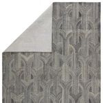Back side of the rug folded to reveal the underside with a lighter version of the trellis pattern