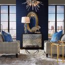 Lucius Mirror in antique silver leaf finish hanging on blue geometric wallpaper above decorative chest