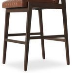 Close-up angled shot showing padded leather backrest and rear wood support