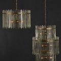 Two Electra Chandeliers in different sizes shown hanging against dark wall background