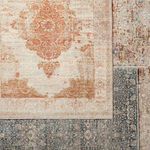 Overlapping view of Beatty Medallion rust rug with a blue patterned rug beneath