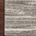 Beige rug with soft plush pile featuring horizontal stripes in varying shades of beige, gray, and subtle blue accents