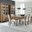 Chapman Upholstered Chairs in dining area with glass door cabinets and patterned rug under table