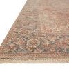 Priya Brick Navy rug angled view showing flat weave texture and fringed edge on a white background