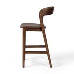 Three-quarter side view highlighting angular design of legs and rounded backrest