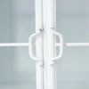 Close-up of white metal handles on glass pane doors with slight wear marks