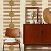 Wallpaper shown in styled room with mid-century wooden chair, books, sideboard, and decorative objects