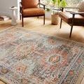 Jocelyn Mist rug shown in living room setting with leather chairs and large windows