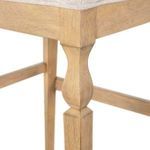 Detailed view of turned leg design and wood grain finish on Gaston Stool's wooden frame