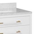 Close-up of three gold hardware drawer pulls on white vanity with marble countertop edge