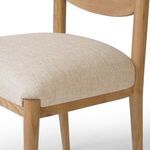 Close-up showing cushion fabric and wood frame joint at seat’s front corner