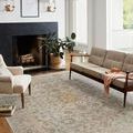 Second styling shot showing Rosemarie rug in living room with beige sofa, armchair, and natural light