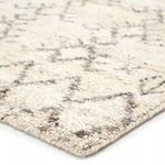 Close-up angled view showing thick wool pile and detailed geometric pattern of rug
