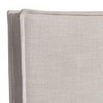 Close-up detail of stitched and flanged edge on fabric upholstered headboard in light beige