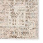 Close-up of rug corner highlighting faded light pink and brown geometric motifs and detailed weaving